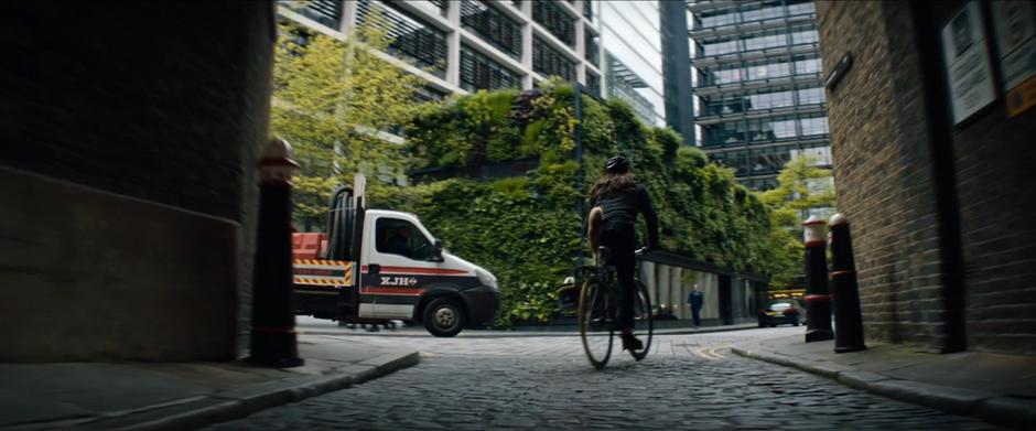 Lara emerges from the square and sees a truck driving past.