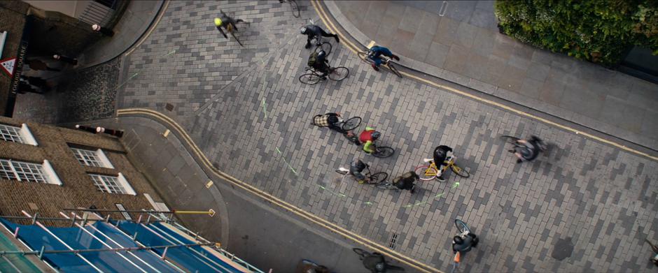 The bicyclists examine the line of paint that comes to a stop in the middle of the street.