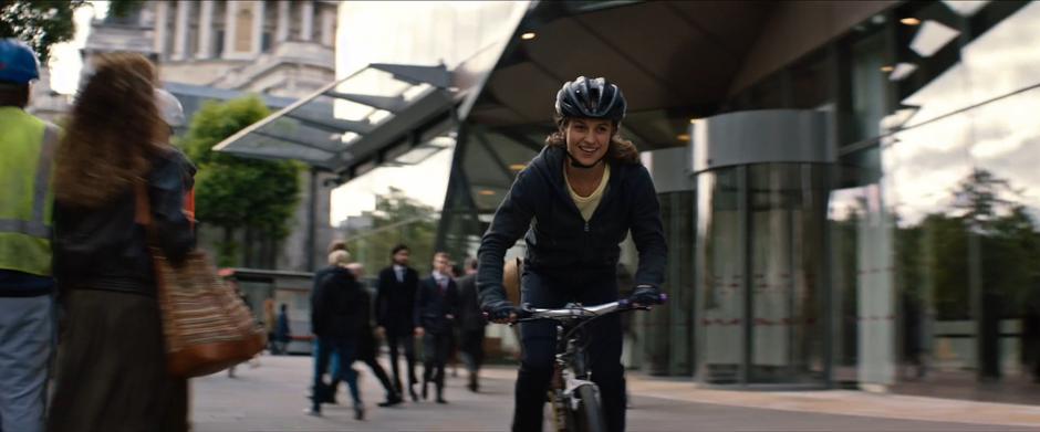 Lara smiles as she rides down the sidewalk.