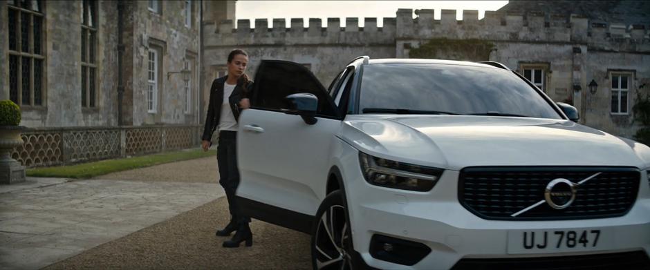 Lara steps out of her car in front of the mansion.