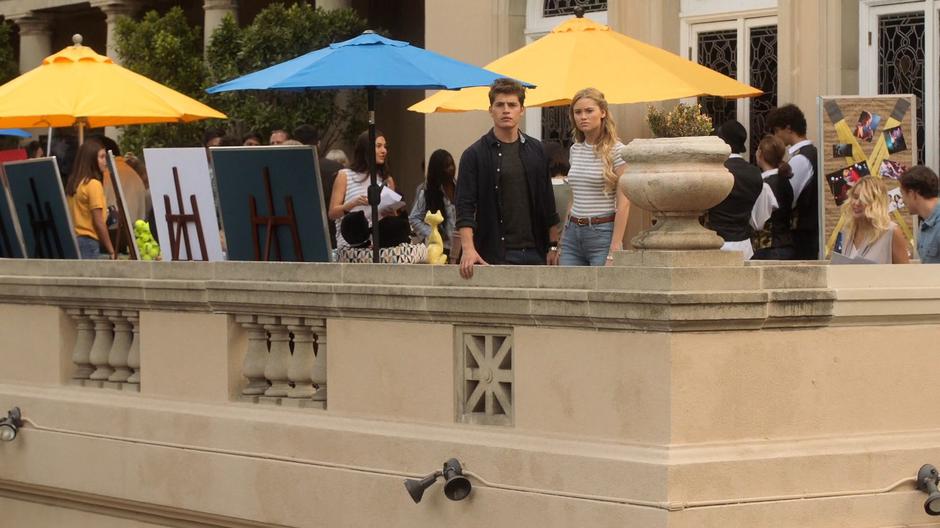 Chase and Karolina look out from the terrace to where Alex & Gert's parents are talking.