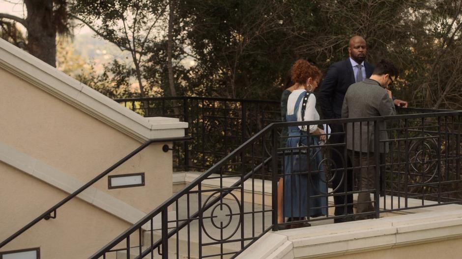 Catherine, Geoffrey, Stacey, and Dale stop on the exterior landing to talk privately.