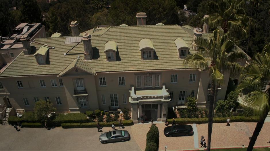 Aerial establishing shot of the school as cars pull up to drop off students.