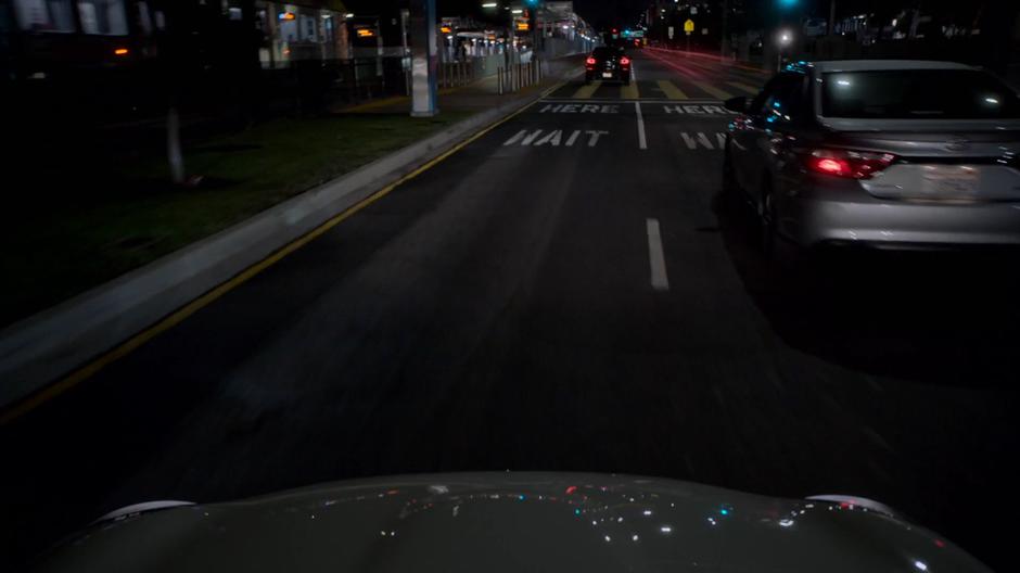 Karolina weaves between other car while following the trail of light that leads to Alex.