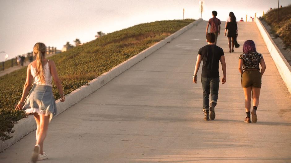 The kids walk back up the ramp leading away from the beach.