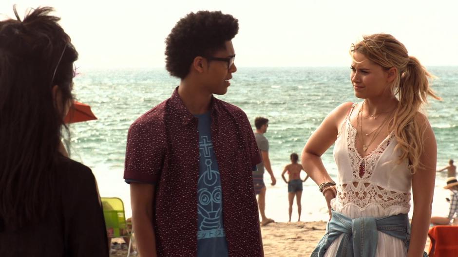 Alex looks over at Karolina as they chat on the beach.