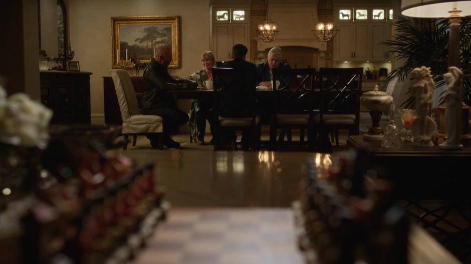 Mick and Nate sit at the table eating sandwiches with Dorothy and Henry Heywood.