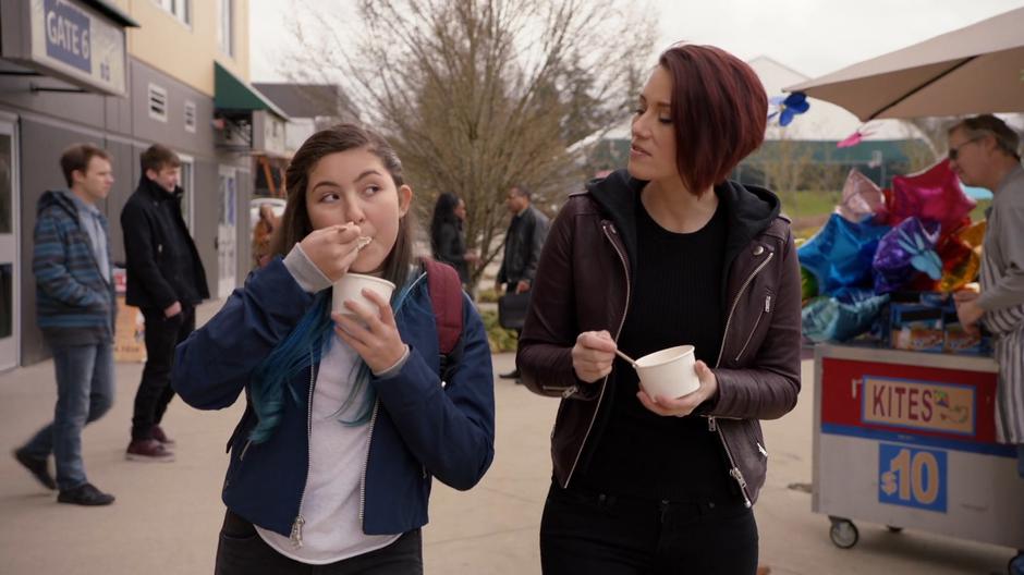 Ruby and Alex eat their ice cream while walking through the park.