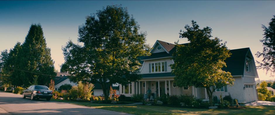 The family walks out of the house with Margo's suitcases to take her to the airport.