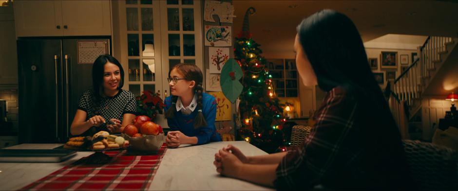 Margo talks to Kitty and Lara Jean while making cookies during her Christmas visit.