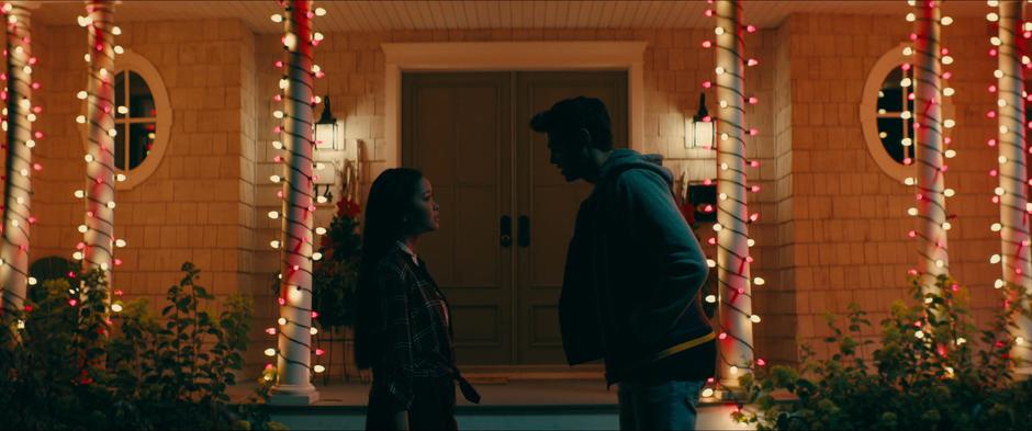 Peter tries to reassure Lara Jean that nothing happened between him and Gen while they house is lit up by Christmas lights behind them.