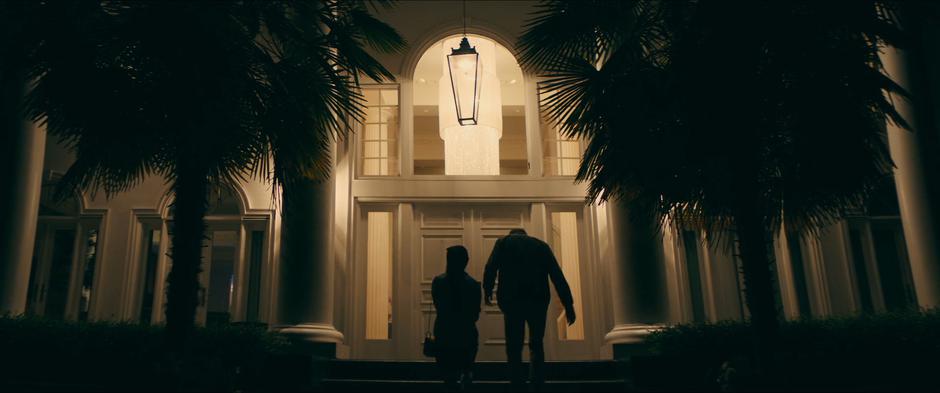 Lara Jean and Peter walk up the steps to the front door of the mansion.
