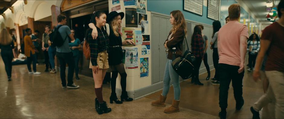 Chris puts her arm over Lara Jean's shoulder and makes fun of Gen's uggs after Gen tries to make fun of Lara Jean's shoes.