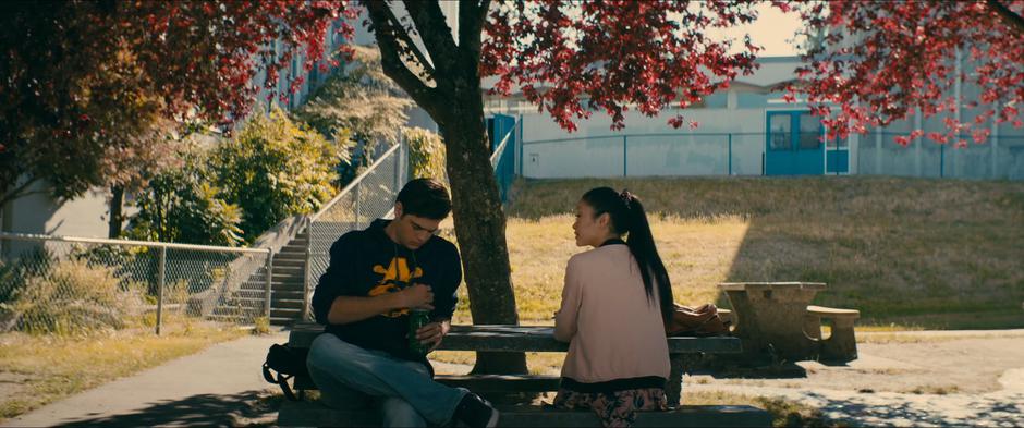 Peter and Lara Jean hash out the rules of their relationship at the picnic table by the track.