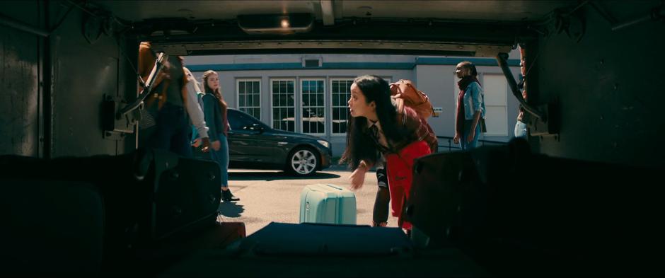 Lara Jean looks up from where she is unloading her suitcase when Gen calls out her name.