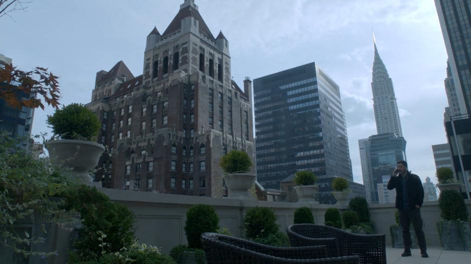 Clem talks to Jane on the phone while standing on the balcony with the Empire State Building in the background.