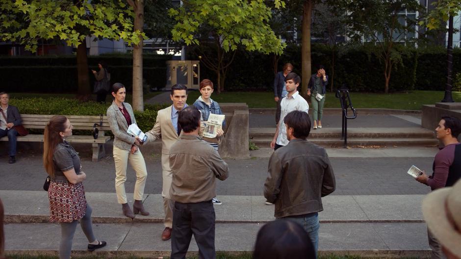 Ben Lockwood talks to a group of people while wearing a nice suit.