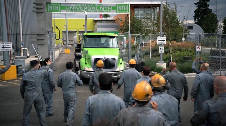 The employees of Lockwood Family Steel yell as they block the path of the delivery truck leaving the factory.