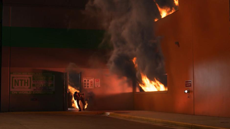 An employee of the new factory runs out of the building as it burns.