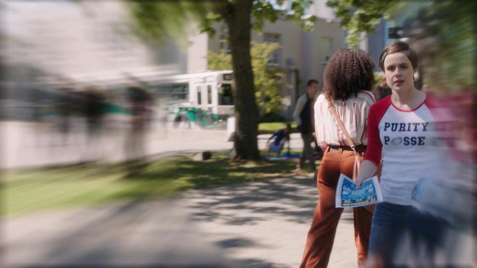 Penelope from the Purity Posse tries to hand Angela Wu a flier as she follows Macy.