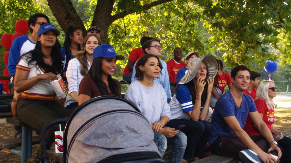 Iris, Caitlin, Cecille, and Nora watch the game from the bleachers.