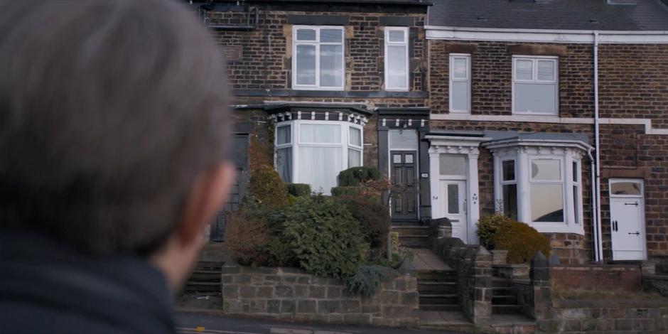 Graham stares over at the empty house from across the street.