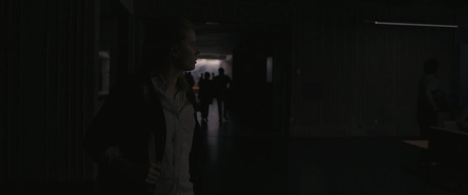 Louise looks around as she walks to class and sees the students in the hallway distracted by the news.