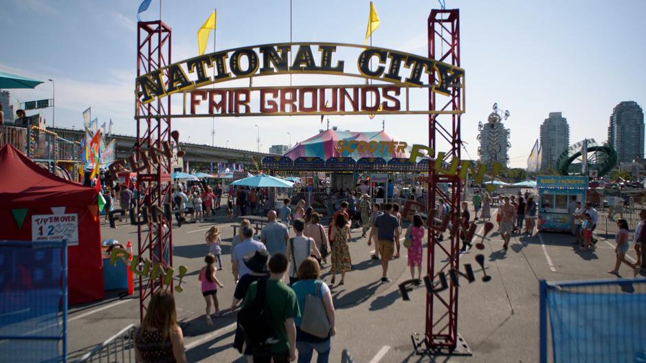 People walk in through the gate into the carnival.