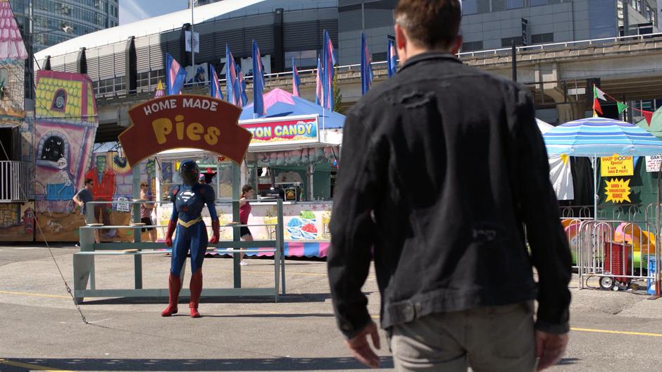 Kara gets the attention of one of the mind-controlled aliens while wearing the containment suit.