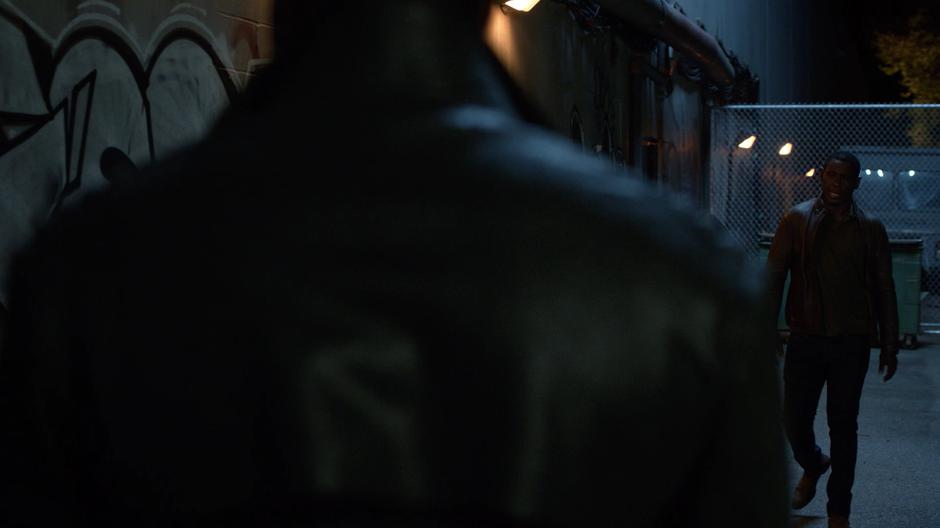 J'onn walks down the alley to ask Manchester Black what he learned.