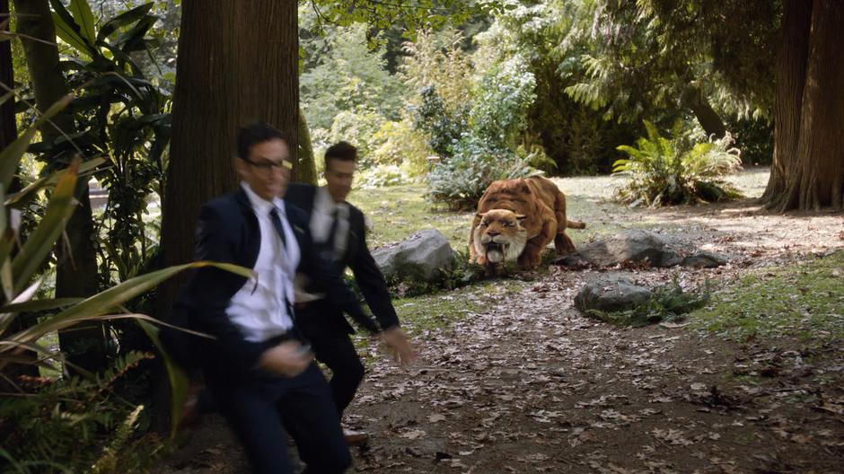 Gary and Nate run towards the time portal as the saber-toothed tiger prepares to leap at them.