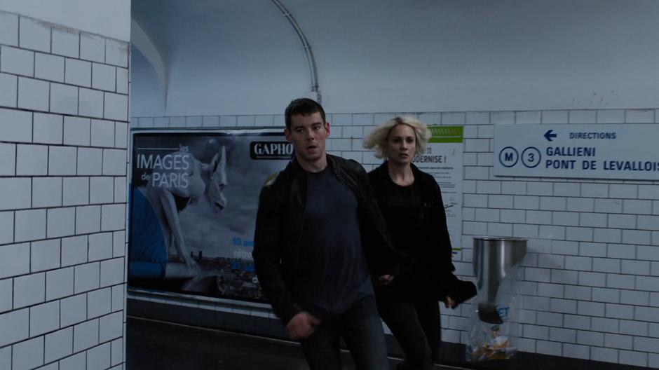 Will and Riley run around the corner through the tunnel leading down to the platform.