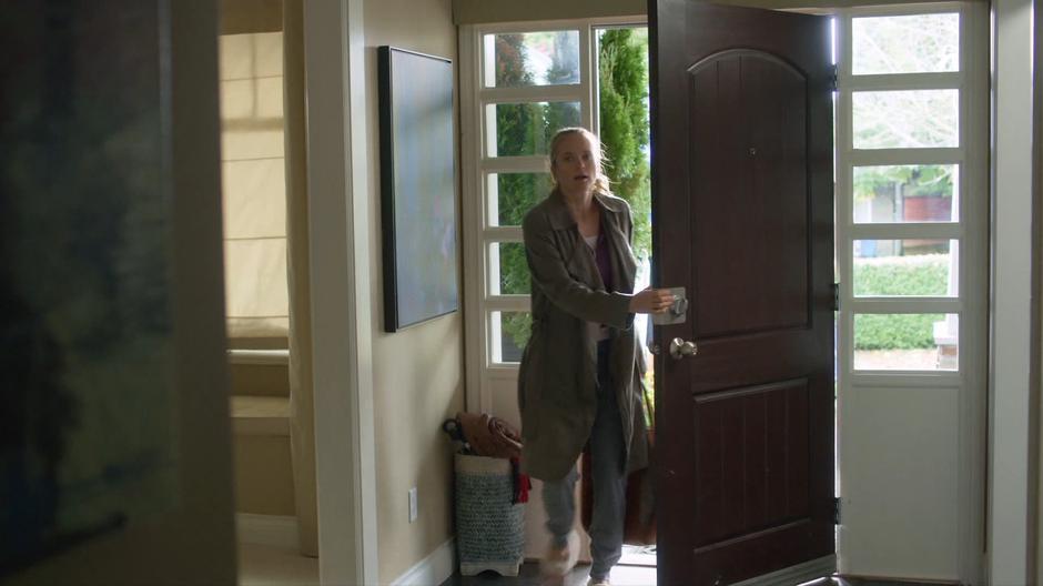 Emma walks into the house through the front door and calls out.
