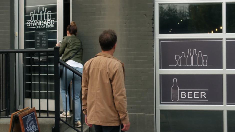 Ben watches as Izzy walks into the liquor store.