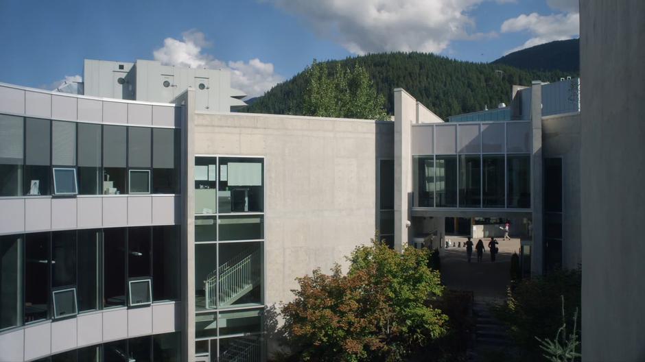 Students walk through the arch leading to the courtyard of the building.