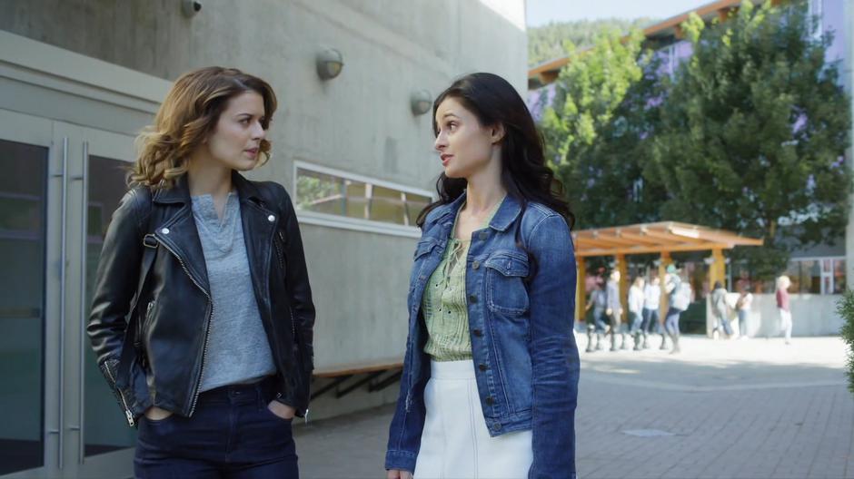 Izzy and Nina talk while walking through the arch leading into the courtyard.