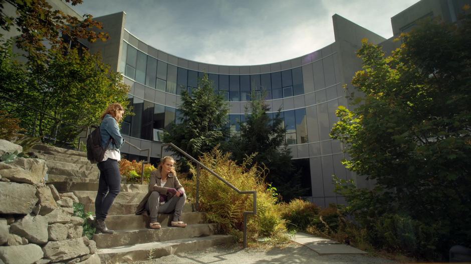 Izzy stops on the steps next to Emma as she is sitting down after her talk with Jack.