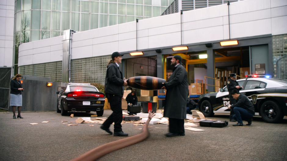 The two security guards carry a priceless vase while Ralph's arm extends underneath them.