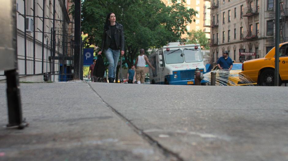 Jessica walks up the street around the corner from her building.