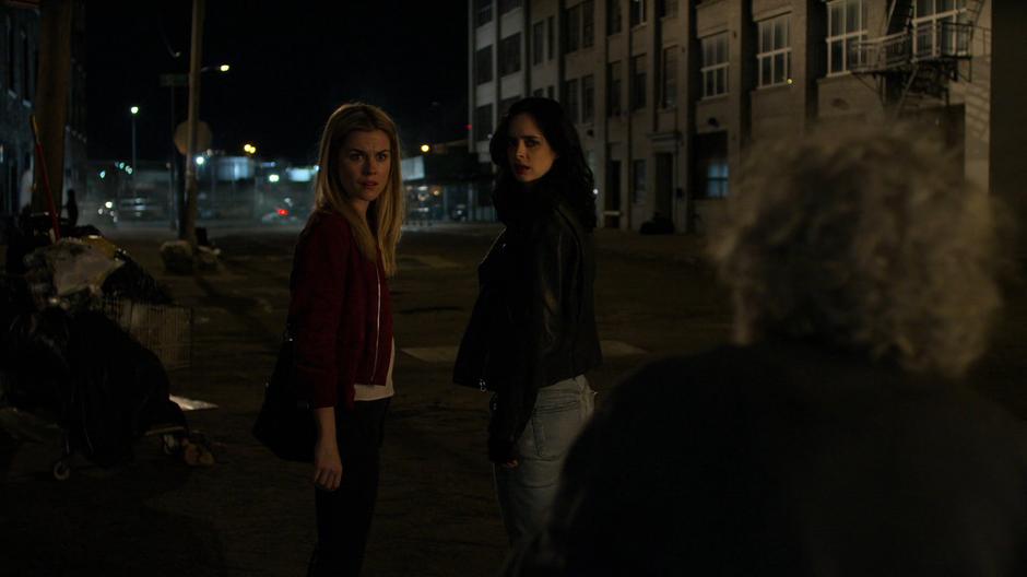 Trish and Jessica glance back at the man after getting information about Inez.