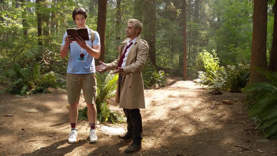 Constantine holds his hands out after Ray grabbed the book from his hand.