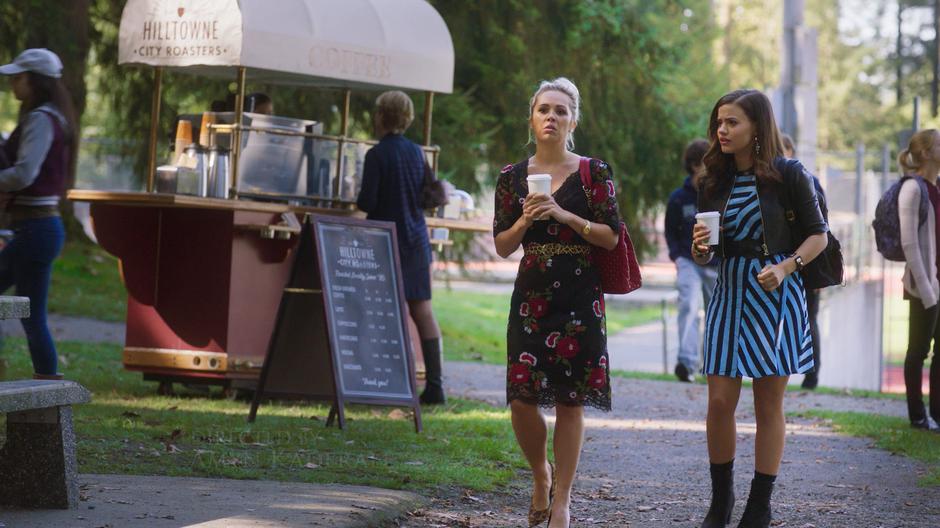 Lucy tells Maggie that Parker broke up with her as they walk down the path with their coffees.