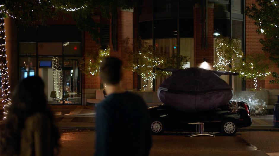 Iris and Barry look over as a pear-shaped Ralph crashes onto a parked car.