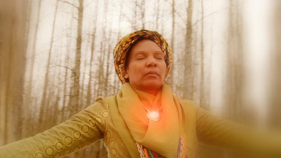 One of the elder totem bearers stands in the circle as her totem glows.