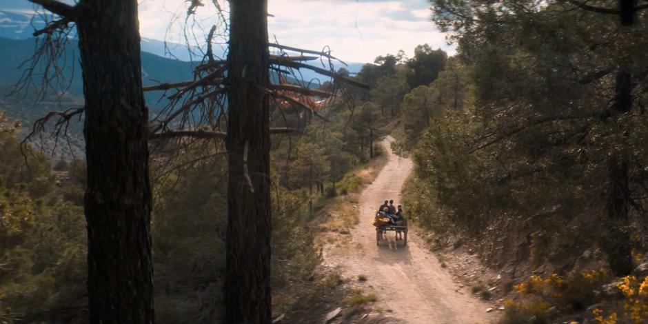 Prem drives his car down the dirt road with the Doctor and her friends.