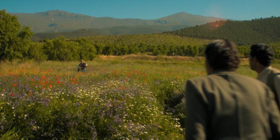 Yasmin and Prem watch as the Doctor runs towards them out of the woods.