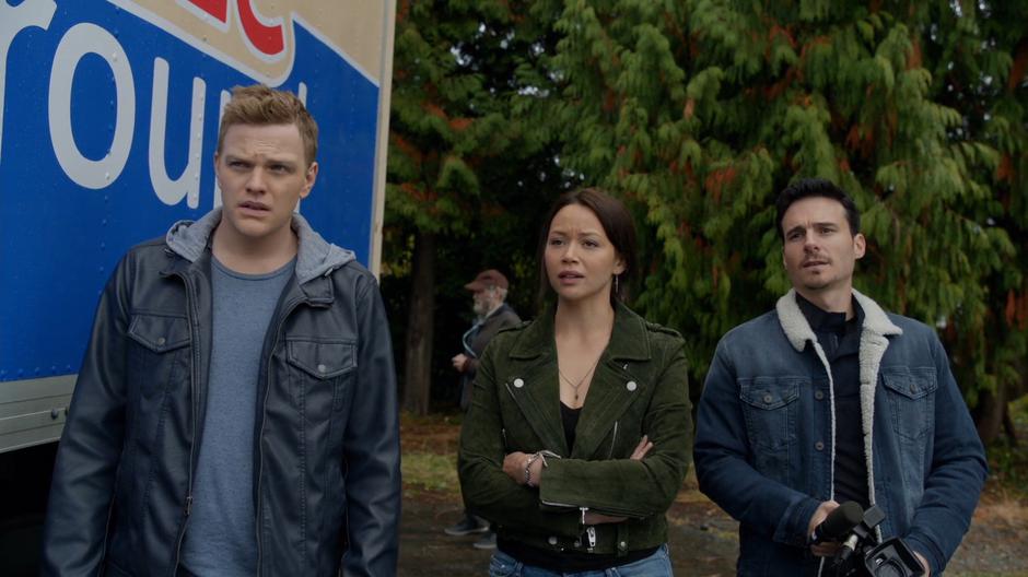 Stan, Suki, and Levon stand beside the truck watching for Liv.