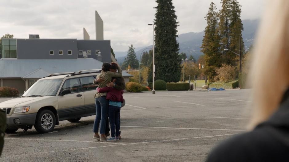 Liv watches as Joann hugs her family after being reunited with them.