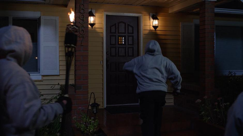 Several members of the Children of Liberty walk up to the front door.