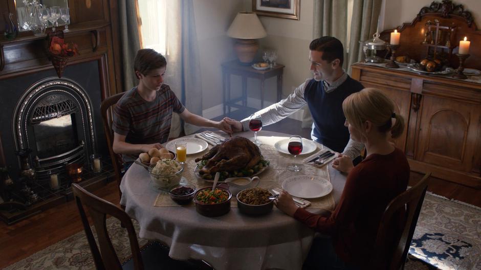 Ben Lockwood holds his son and wife's hands while saying grace before Thanksgiving dinner.